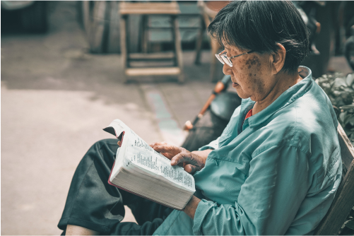 Женщина читает книгу в очках