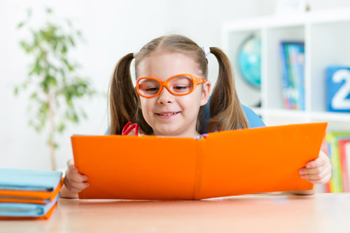 Ребенок в очках читает книгу