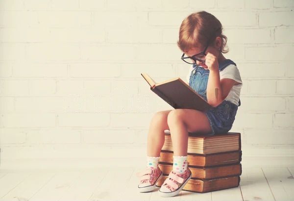 Ребенок в очках читает книгу
