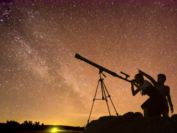 Смотрят на звезды через телескоп